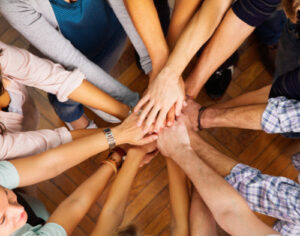 huddle of people with all hands in