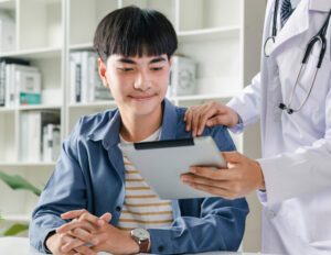 young adult examines medical information with doctor