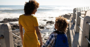 mom and son holding hands looking at each other on ocean lookout